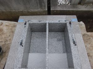 地震対策として、揺れを軽減する黒いゴム状のシートと耐震ボンドで大切なお墓をお守りしています。