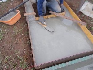 コンクリート打設工。組み込んだ鉄筋の上からコンクリートを流し込みコテで均一にします。一定の養生期間をおいて型枠を外して基礎工事の完成です。